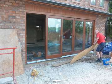 Our new Timber Bi folding doors come with a flush track in Aluminium. We fabricate our Timber Bi folds in Red GRANDIS hardwood as standard. Red Grandis is a light hardwood which can be stained to a range of finish teak is shown in the photo. Our Timber Bi folding doors can be painted any RAL colour you require , Installation Warrington in Cheshire